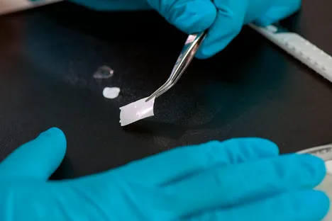 A wound film is touched with tweezers