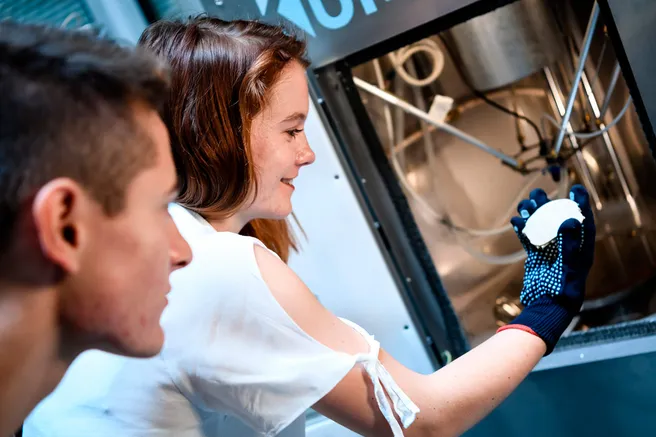 Students remove a part from the 3D printer