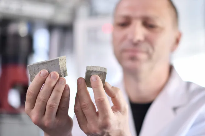 An employee holds broken concrete in his hand